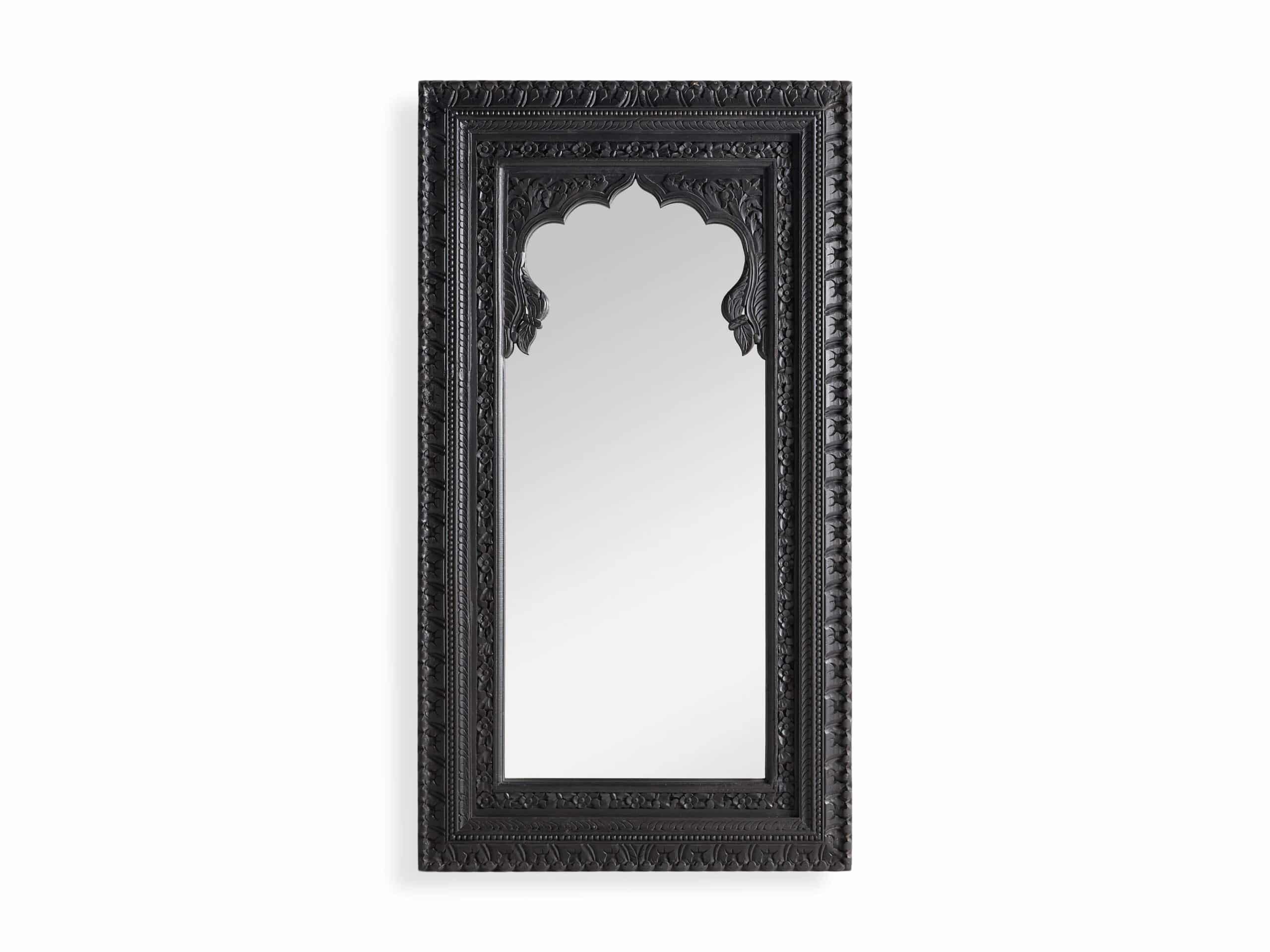 A black, handcarved wooden floor mirror with a mirrored surface and ornate frame.