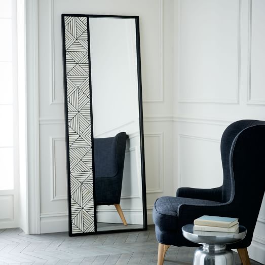A rectangular floor mirror with a geometric bone inlay design