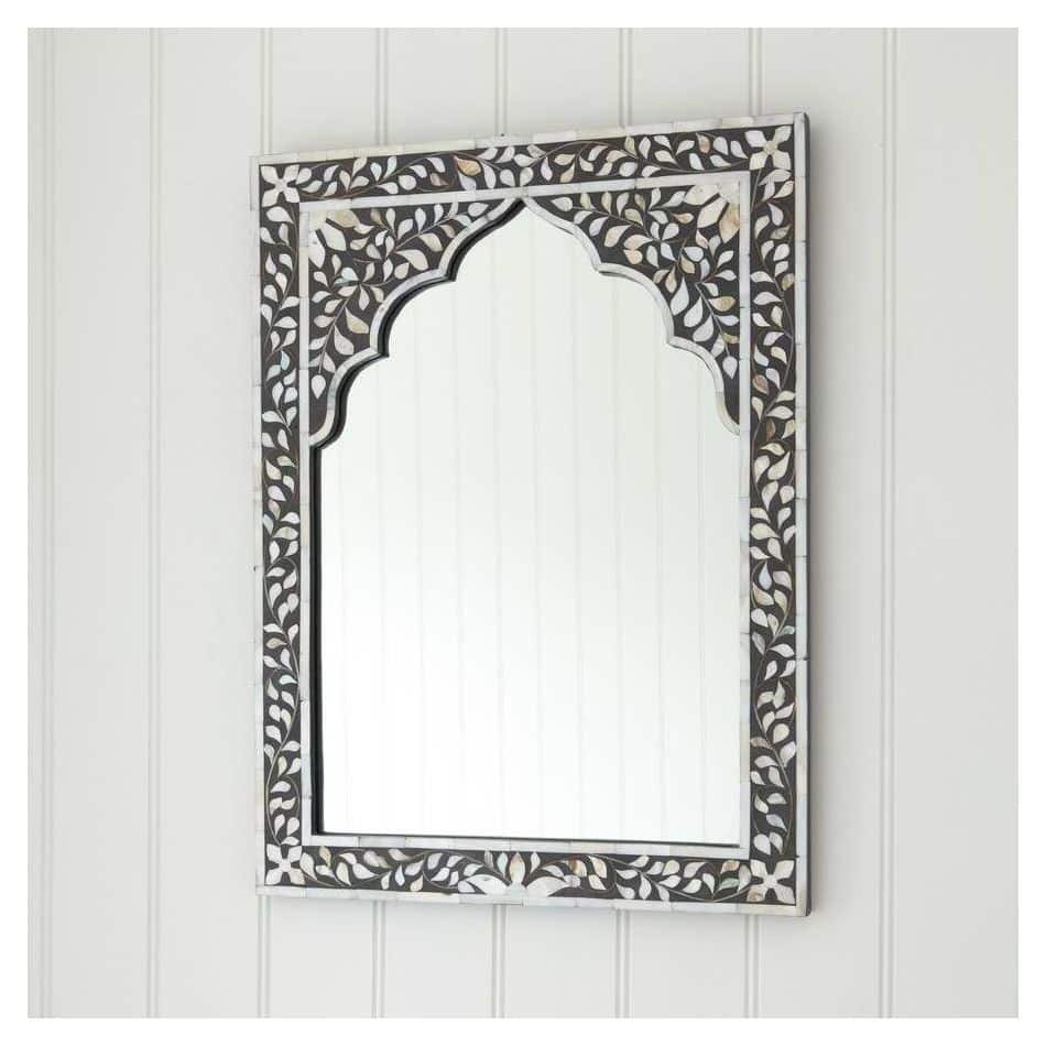 A rectangular mirror with mother of pearl inlay work in a floral pattern on a black wooden frame.