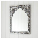 A rectangular mirror with mother of pearl inlay work in a floral pattern on a black wooden frame.