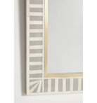 A wall-mounted bone inlay mirror with a striped bone inlay design in beige and gold tones.